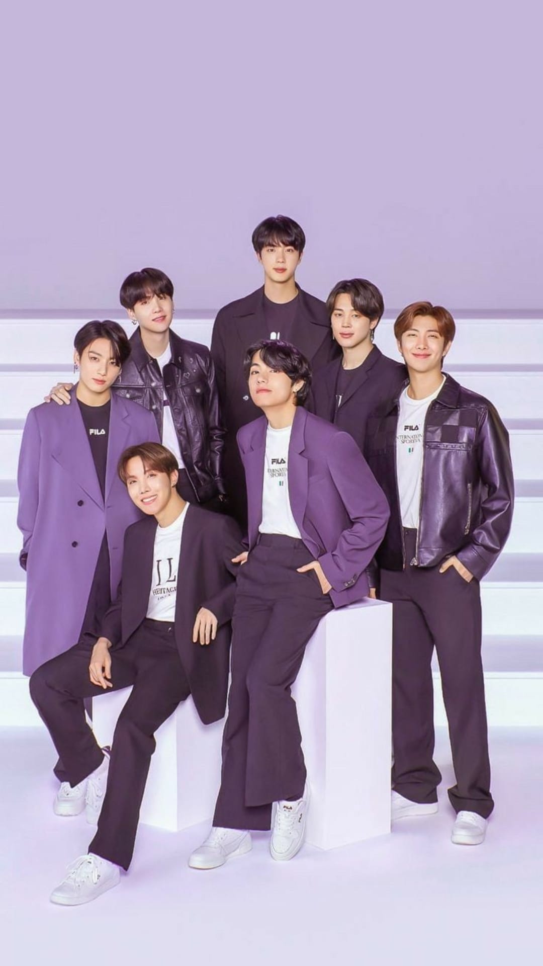 BTS members pose in purple suits and black leather jackets against a lavender backdrop for a group portrait.