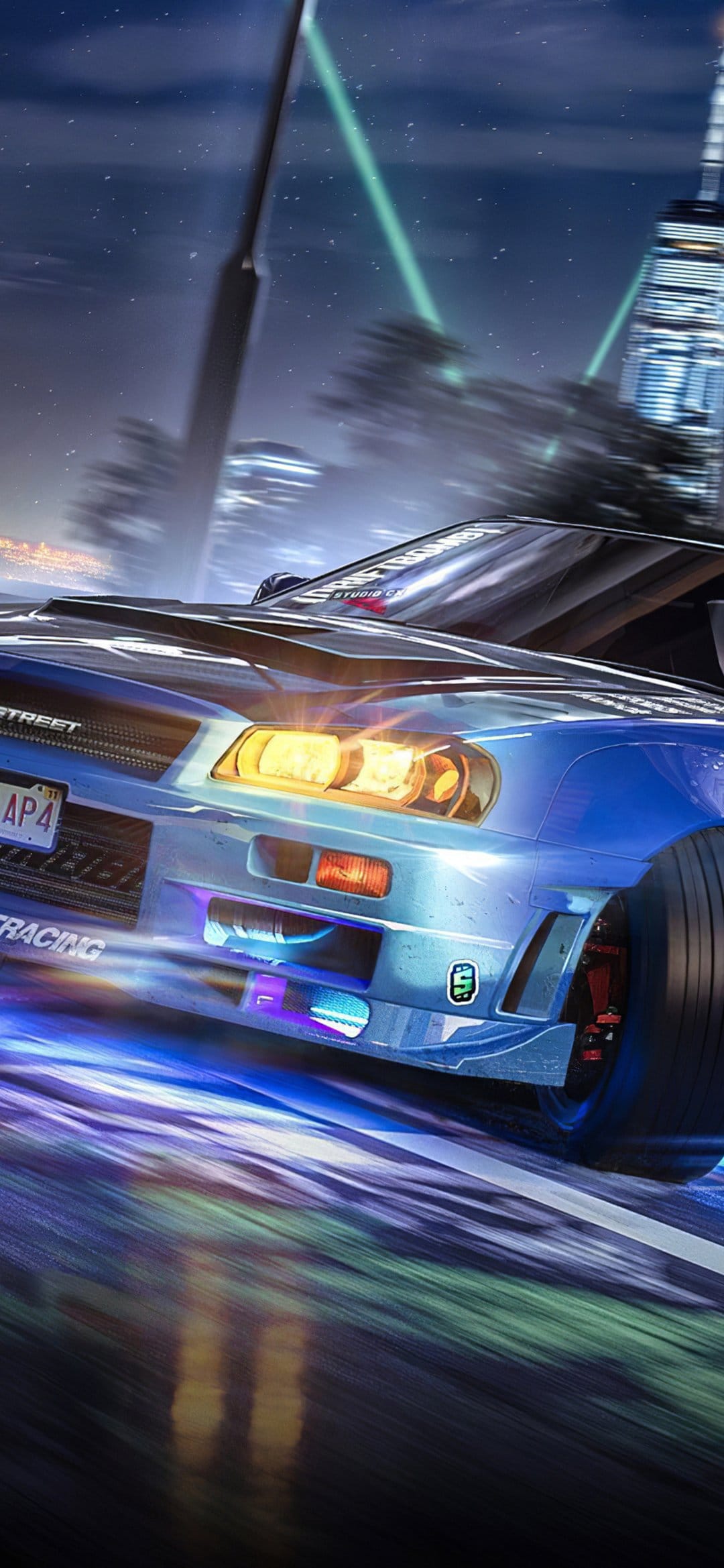 Blue sports car drifting on a city street at night with glowing purple underglow and motion blurred lights.