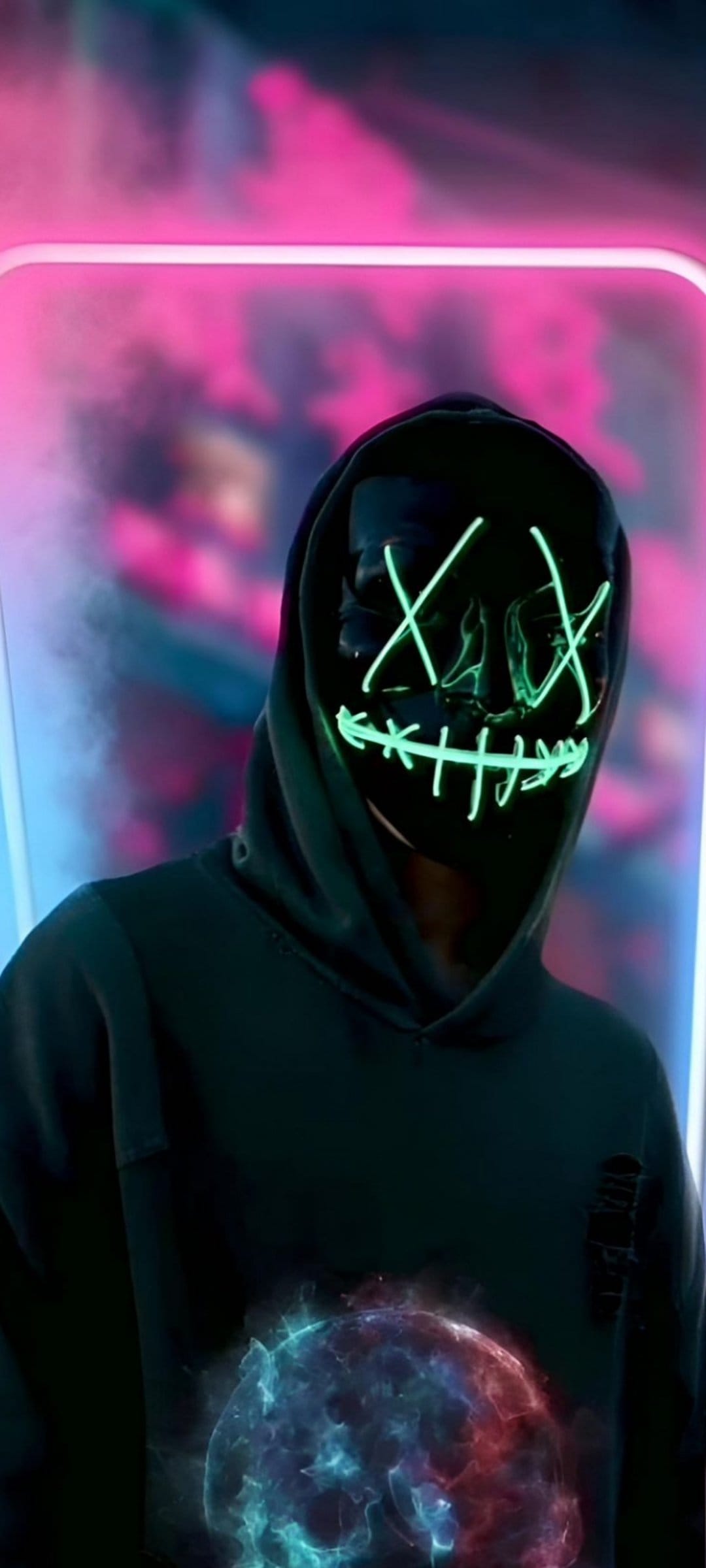 Person in a green LED mask and black hoodie stands near a swirling blue and red orb among pink neon smoke.