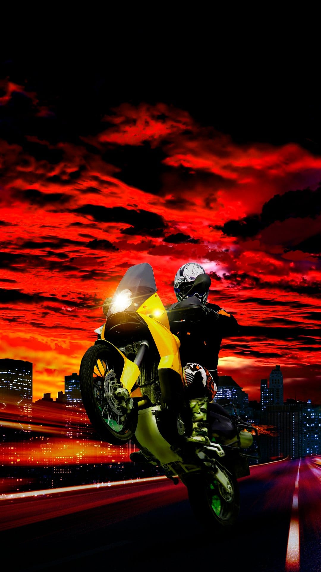 Motorcyclist performs a wheelie against a fiery red sunset sky with blurred city lights in the distance.