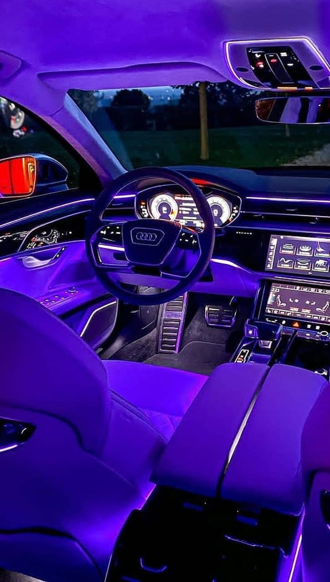 Purple ambient light glows across a luxury car's leather seats, dashboard, and digital infotainment screen.