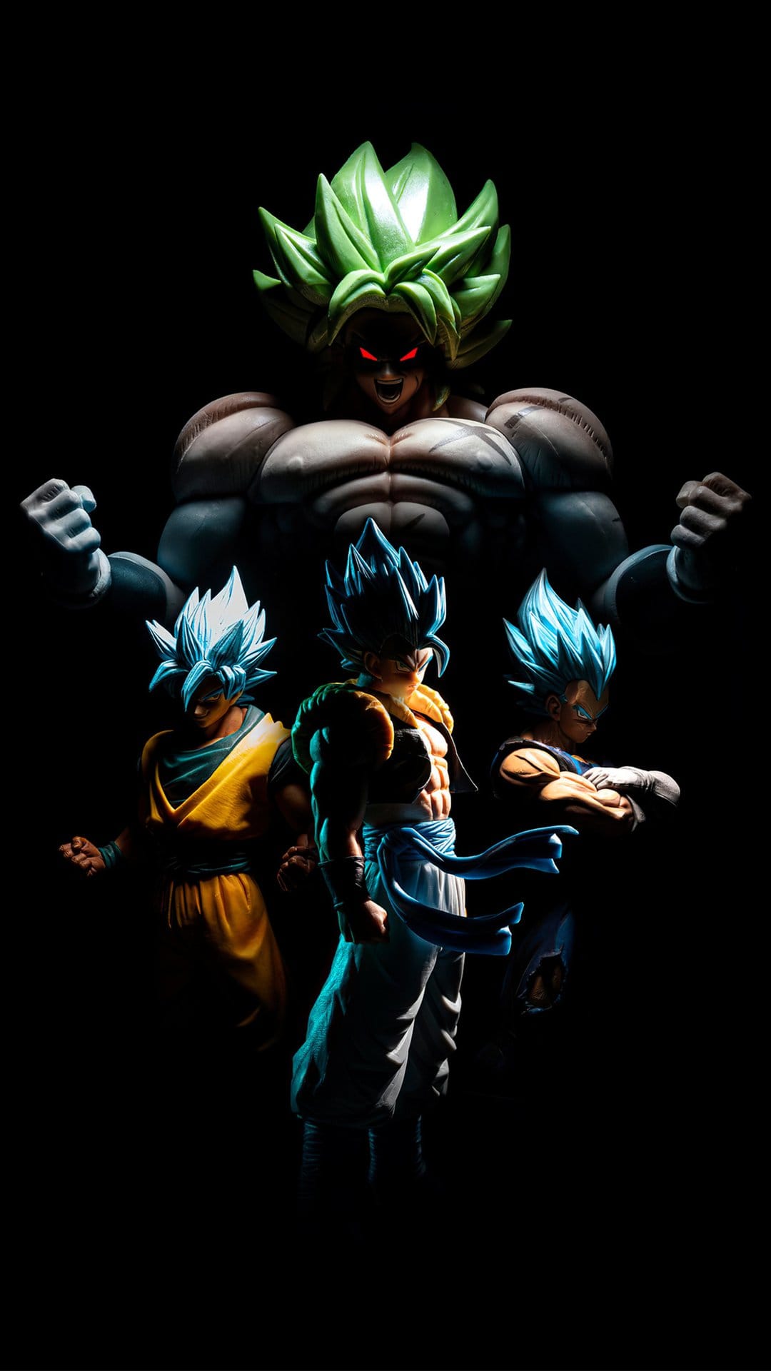 Broly with green hair and red eyes towers over Gogeta, Goku, and Vegeta amidst dramatic shadows and blue glows.