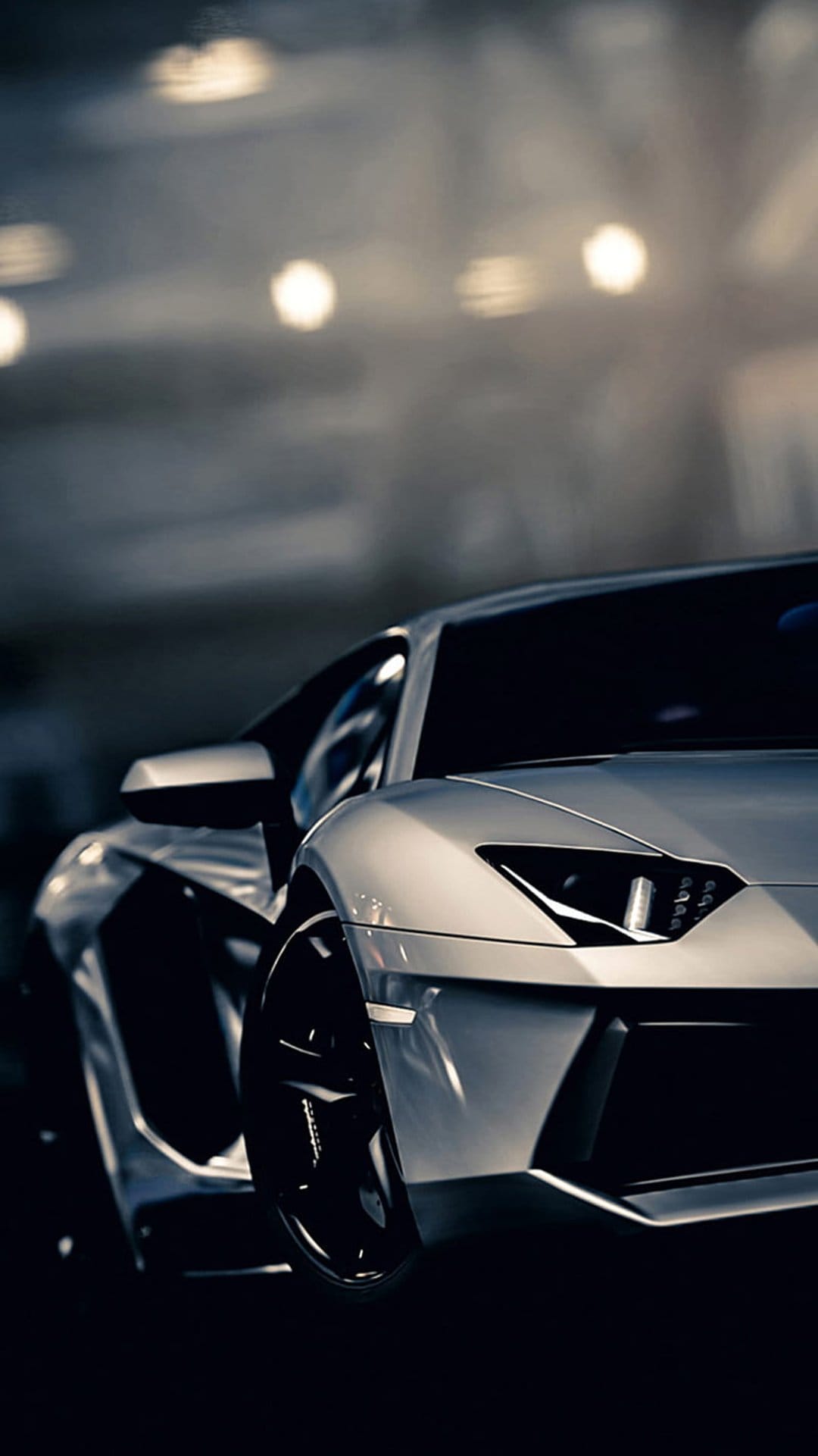 Silver Lamborghini Aventador supercar with glowing headlights and sharp body lines against a dark bokeh background.