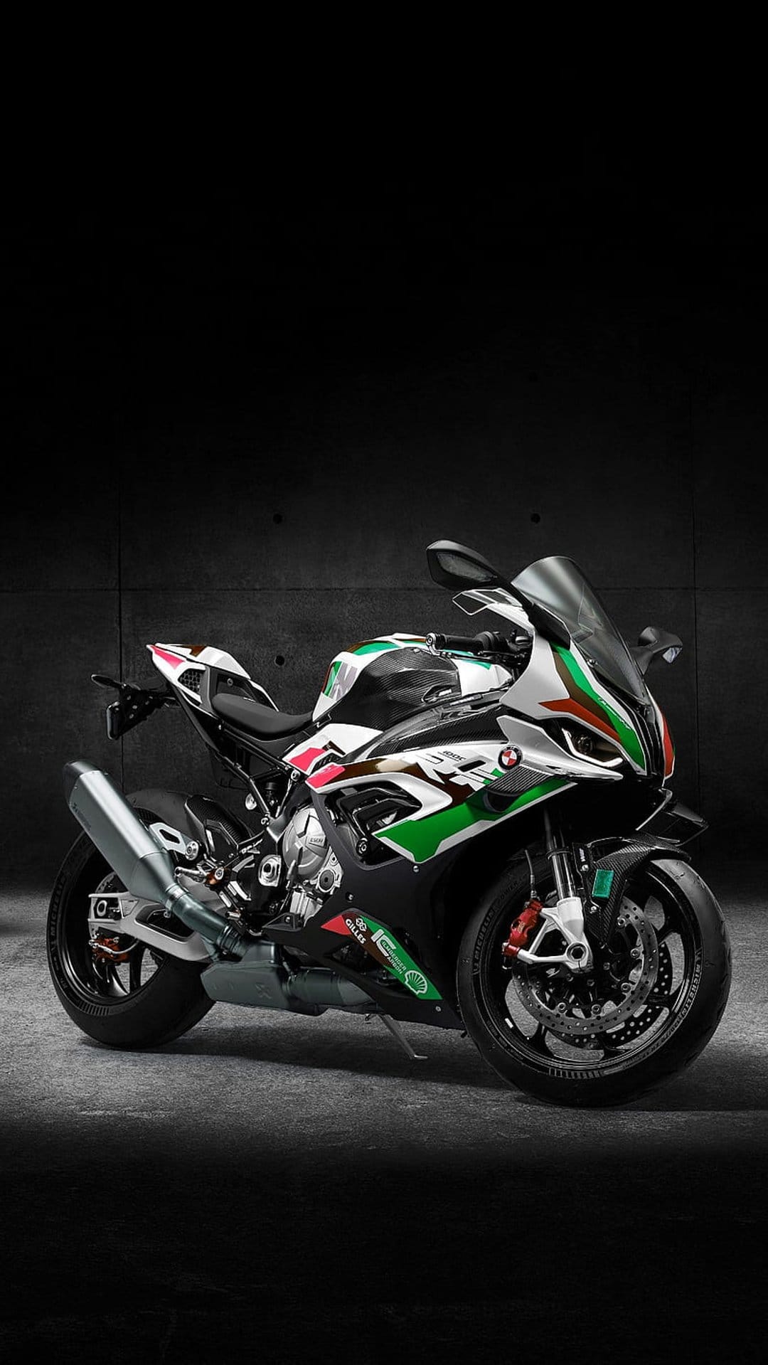 BMW sportbike with green, white, and red racing livery parked against a dark, minimalist studio background.