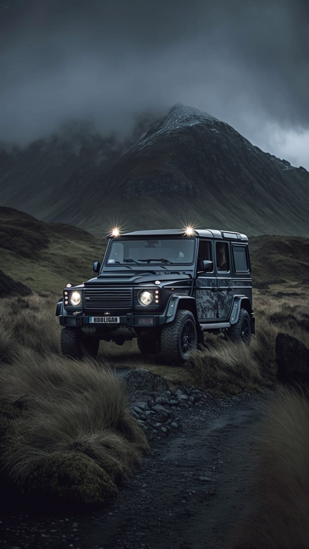 Black Mercedes G-Wagon drives on a rocky path with glowing headlights against a misty mountain background.