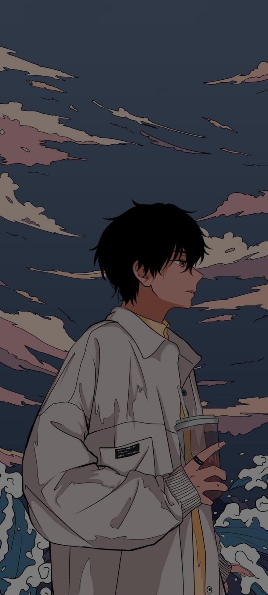 Young man holding a beverage looks at a dramatic sunset sky with swirling pink, orange, and deep blue clouds.