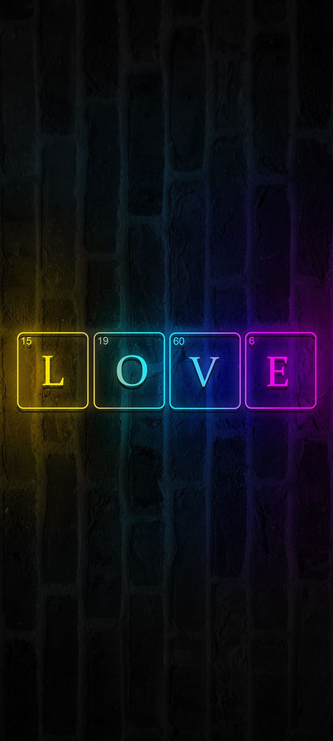 Four neon periodic table squares spelling love glow with pink and white light on a dark textured brick wall.