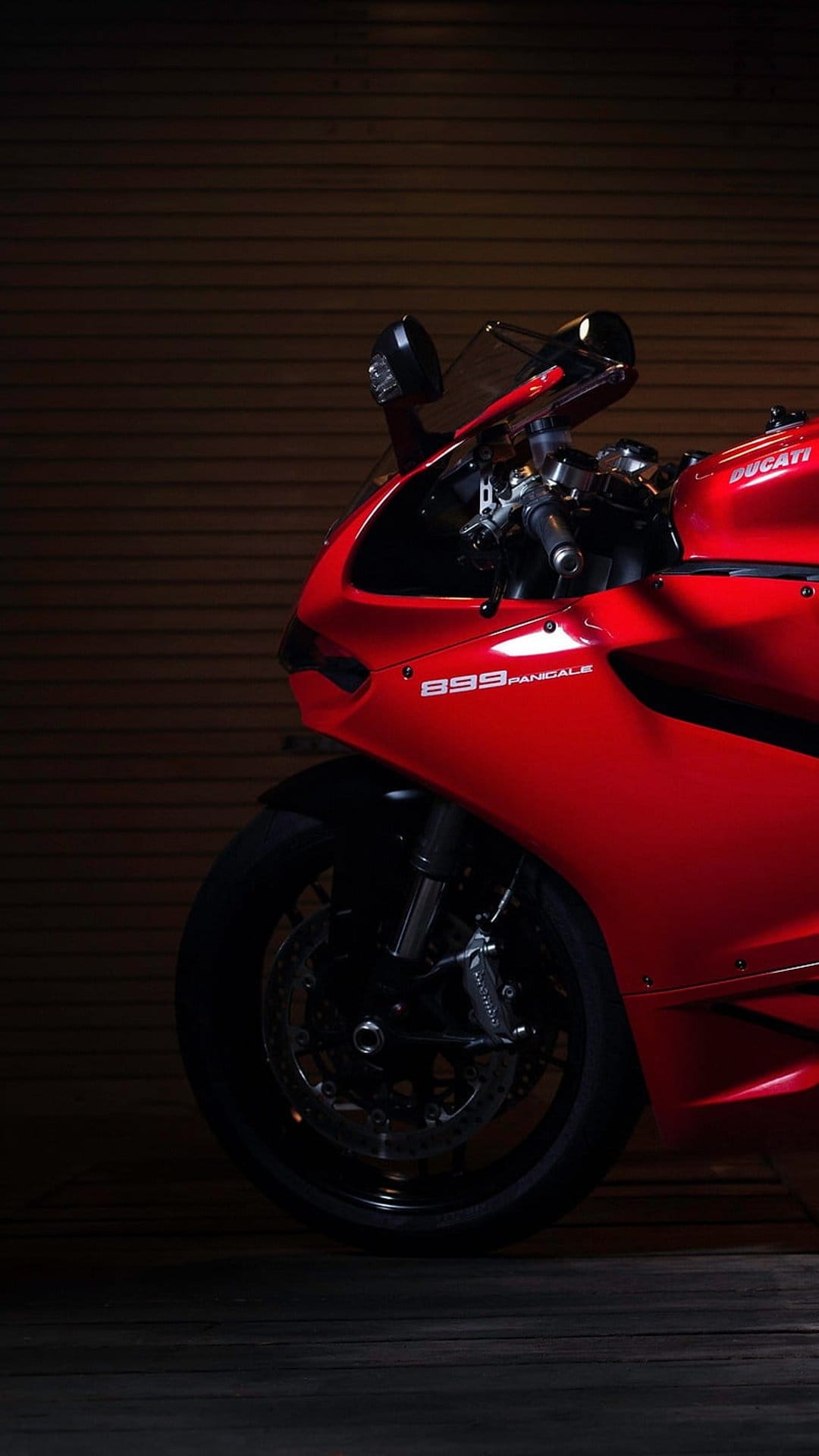 Red Ducati 899 Panigale front wheel and fairings against a dark textured background with Brembo brake detail.