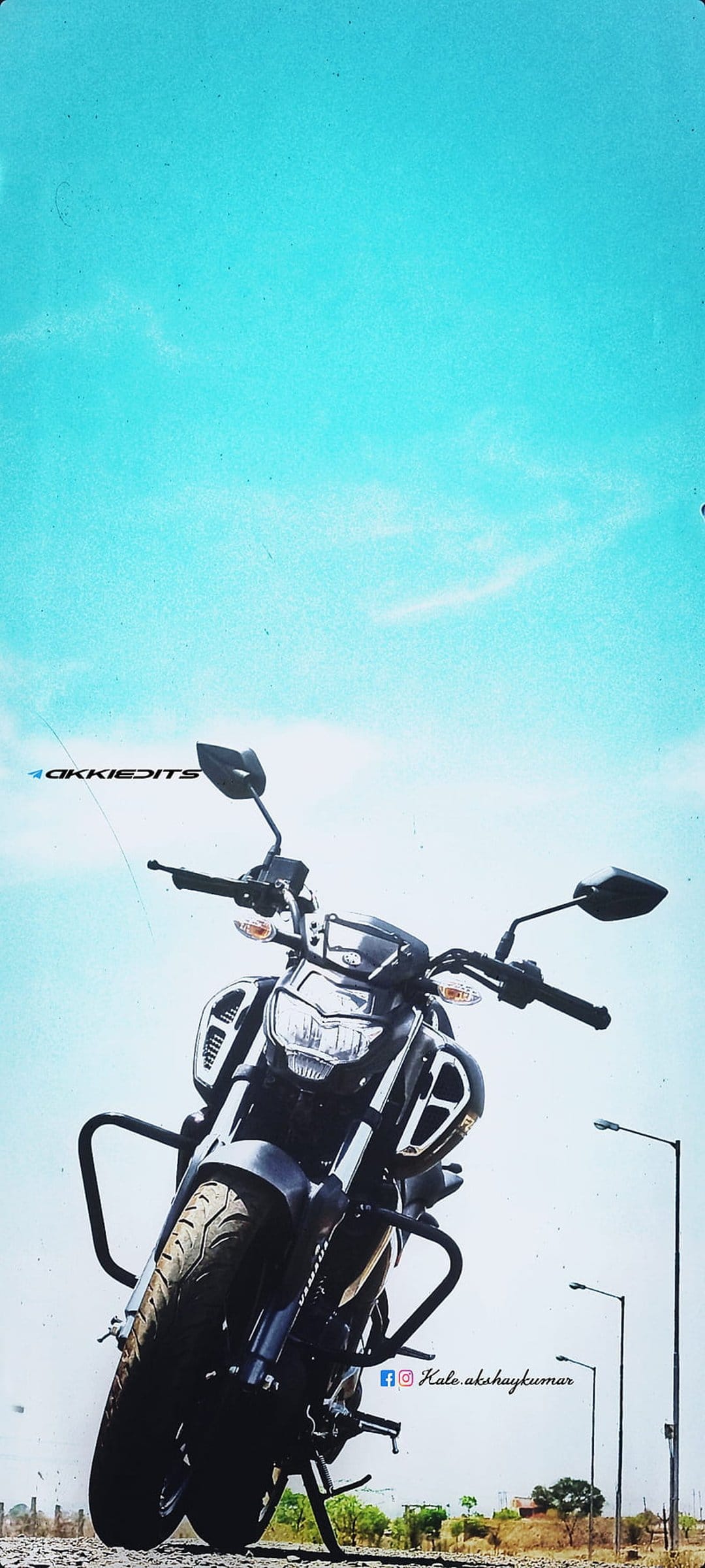 Yamaha FZ motorcycle viewed from a low angle against a cloudy blue sky with urban streetlights in the distance.