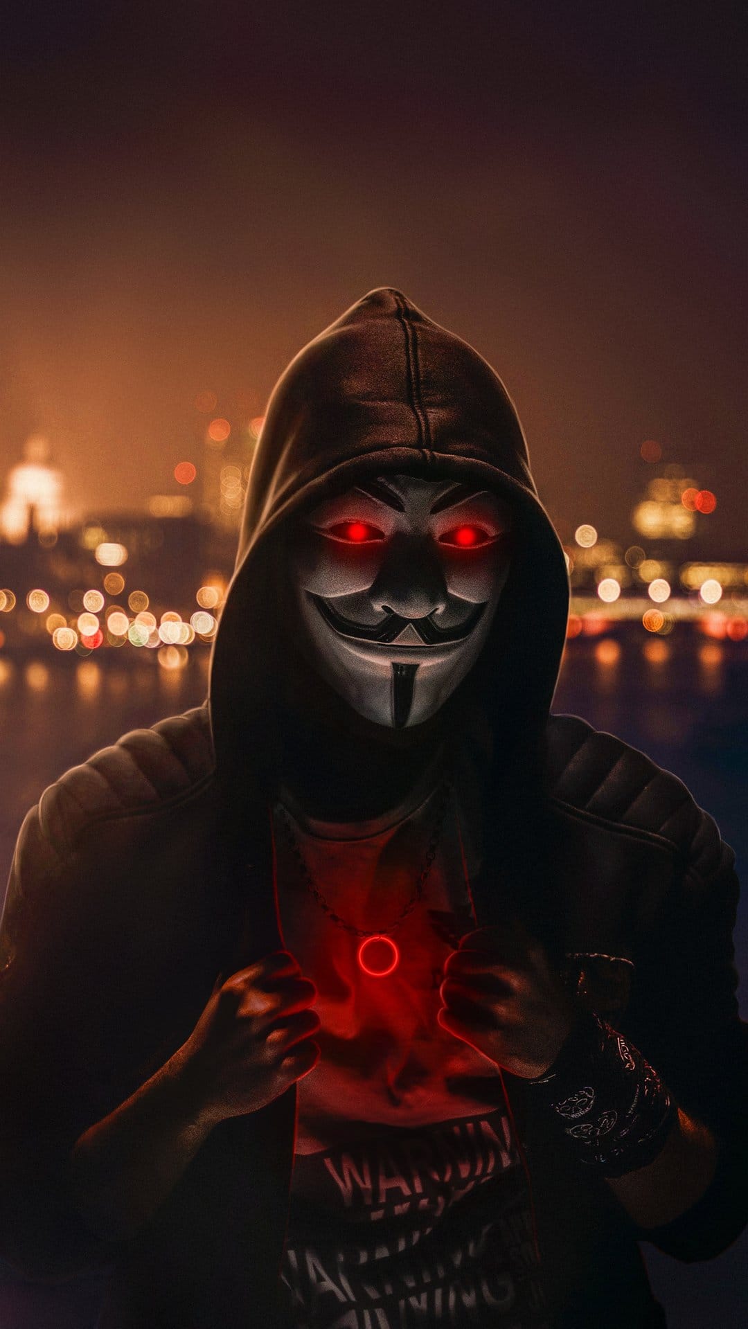 Anonymous hacker in a white mask with glowing red eyes and a dark hoodie against a blurred night city.
