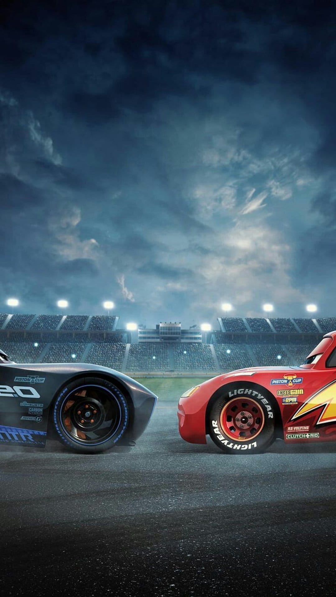 Lightning McQueen and Cruz Ramirez face each other on a dark racetrack under bright stadium lights at night.