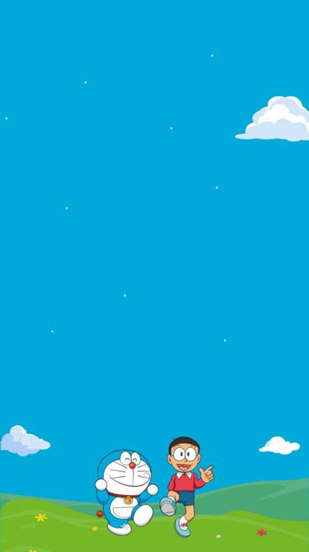 Nobita points forward standing next to a smiling Doraemon in a lush green field under a clear blue sky.