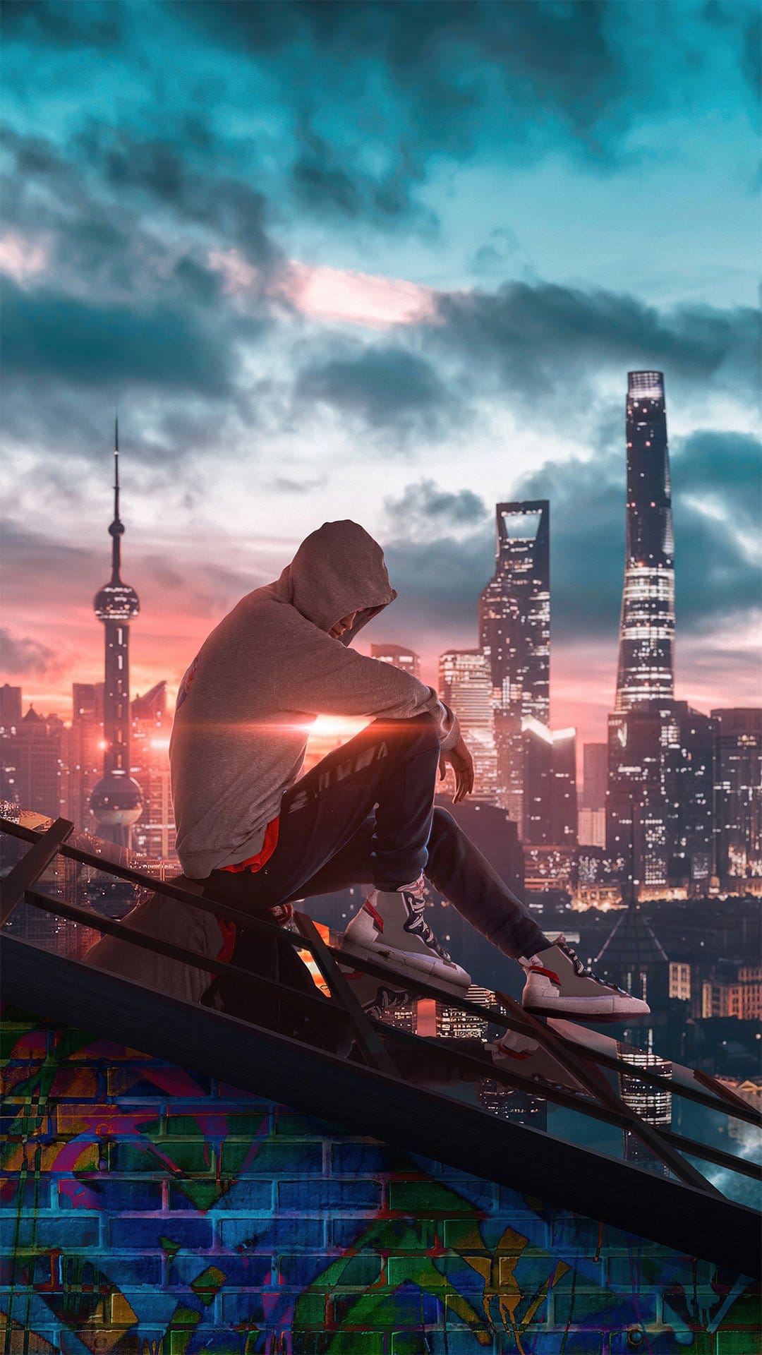 Hooded figure sits on a graffiti ledge overlooking a glowing orange and purple city skyline at sunset.