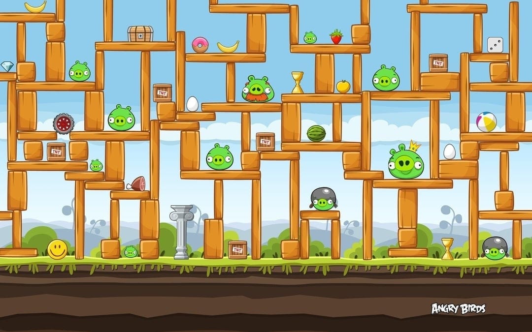 Green pigs and TNT crates inside a large wooden structure against a blue sky in a 2D game level scene.