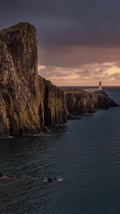 Neist Point, Isle of Skye, Scotland, lighthouse, cliffs, coastline, dramatic, rugged, sunset, twilight, ocean, sea, Atlantic, scenic, natural beauty, Scottish Highlands, remote, island, landscape, serene, breathtaking