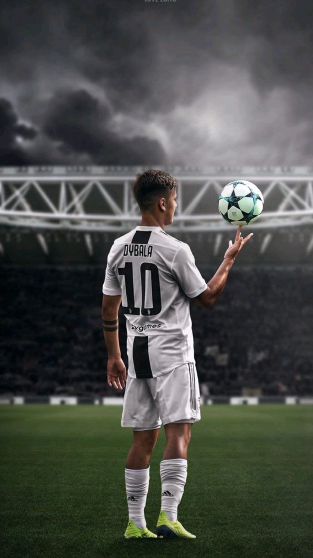 Paulo Dybala wearing his number 10 jersey spins a soccer ball on his finger under a stormy stadium sky.