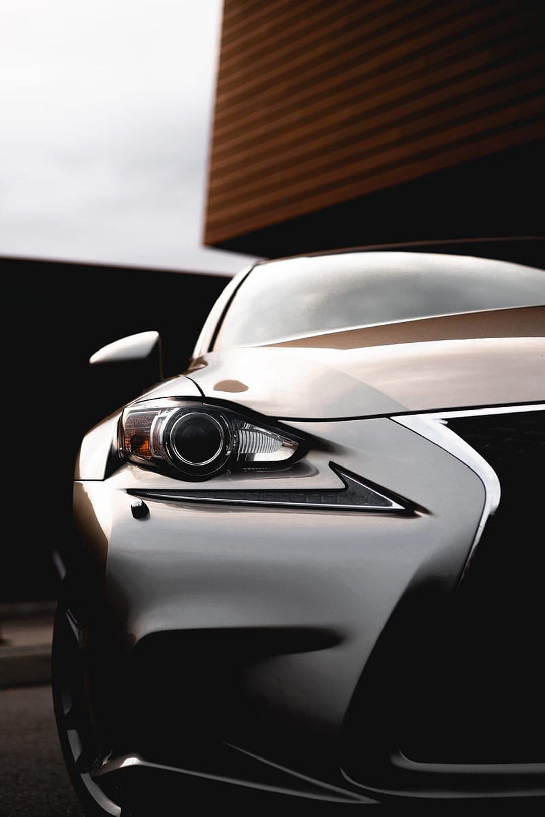 Lexus LED headlight and spindle grille featuring metallic paint reflections and sharp automotive design.