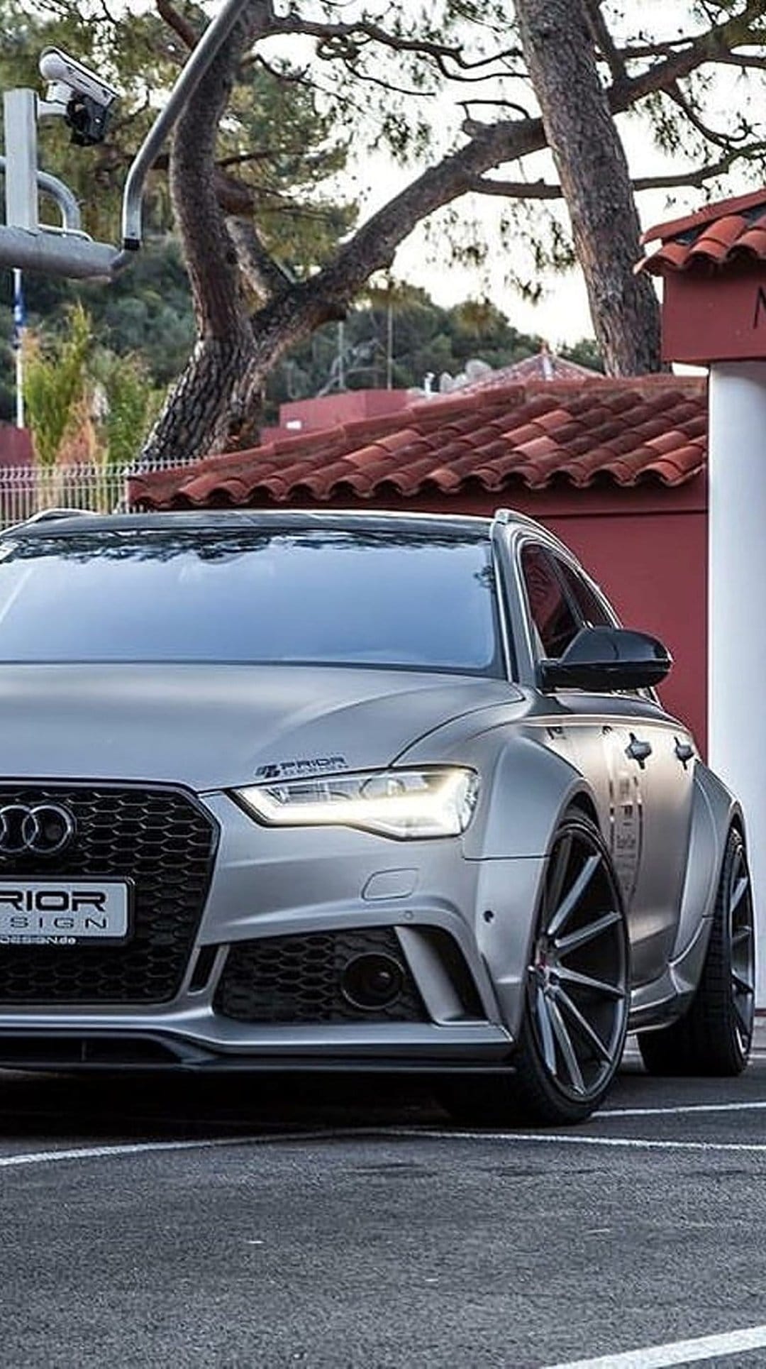 Silver Audi RS6 Avant with a widebody kit, flared fenders, and custom front bumper on a vertical display.