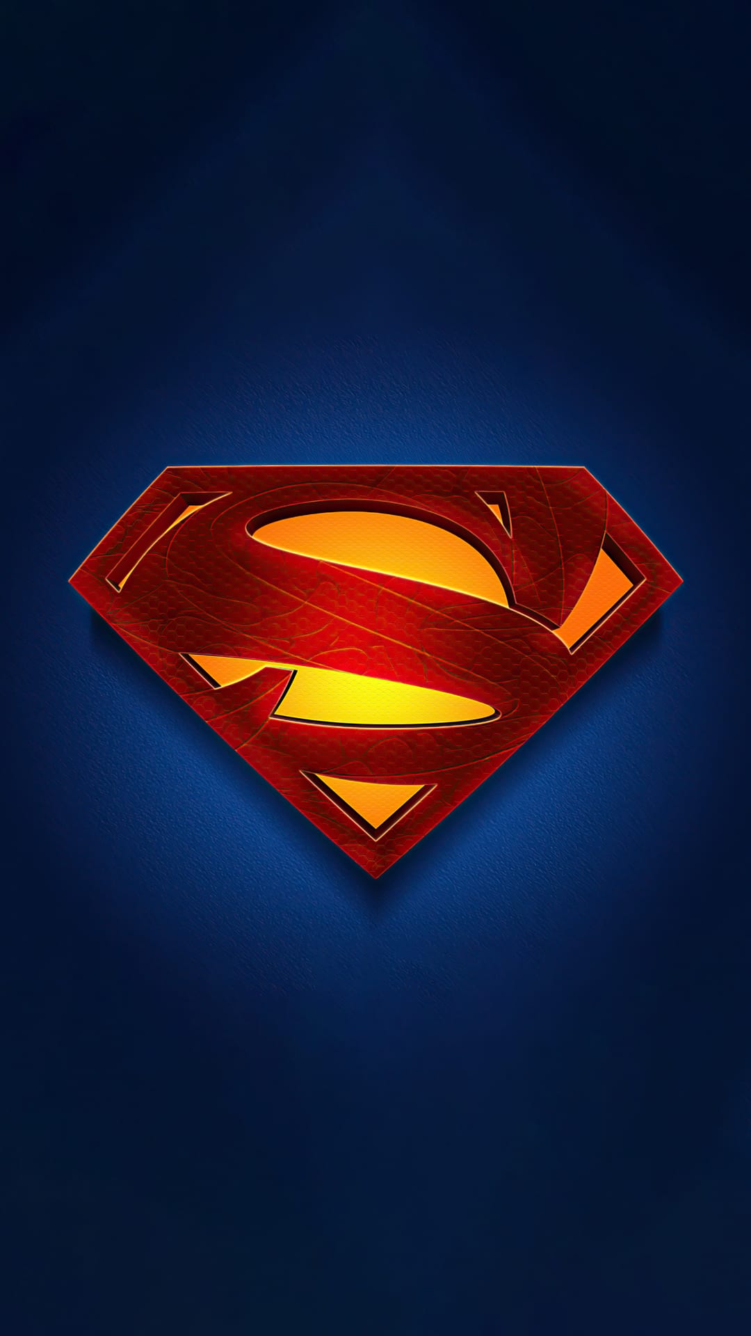 Superman S-shield emblem with a textured metallic finish and beveled edges against a dark navy blue surface.