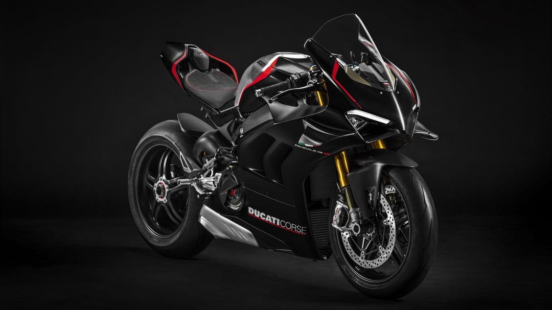 Matte black Ducati Panigale V4 SP sportbike with gold forks and red accents against a dark studio background.