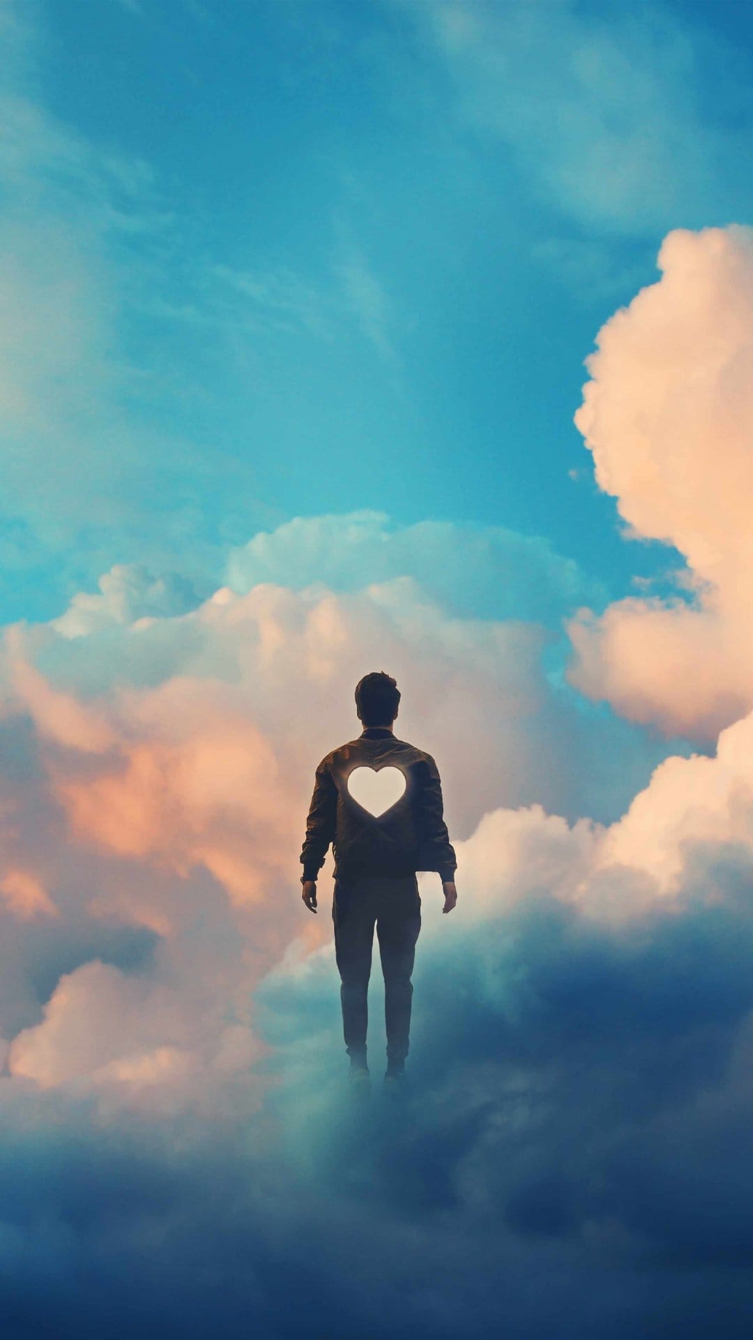 Man with a glowing white heart on his jacket floats above soft orange and pink clouds in a vibrant blue sky.