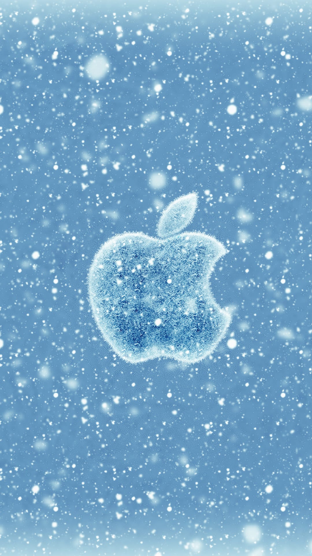 Apple logo made of shimmering ice crystals sits against a blue sky with soft, out-of-focus falling snowflakes.