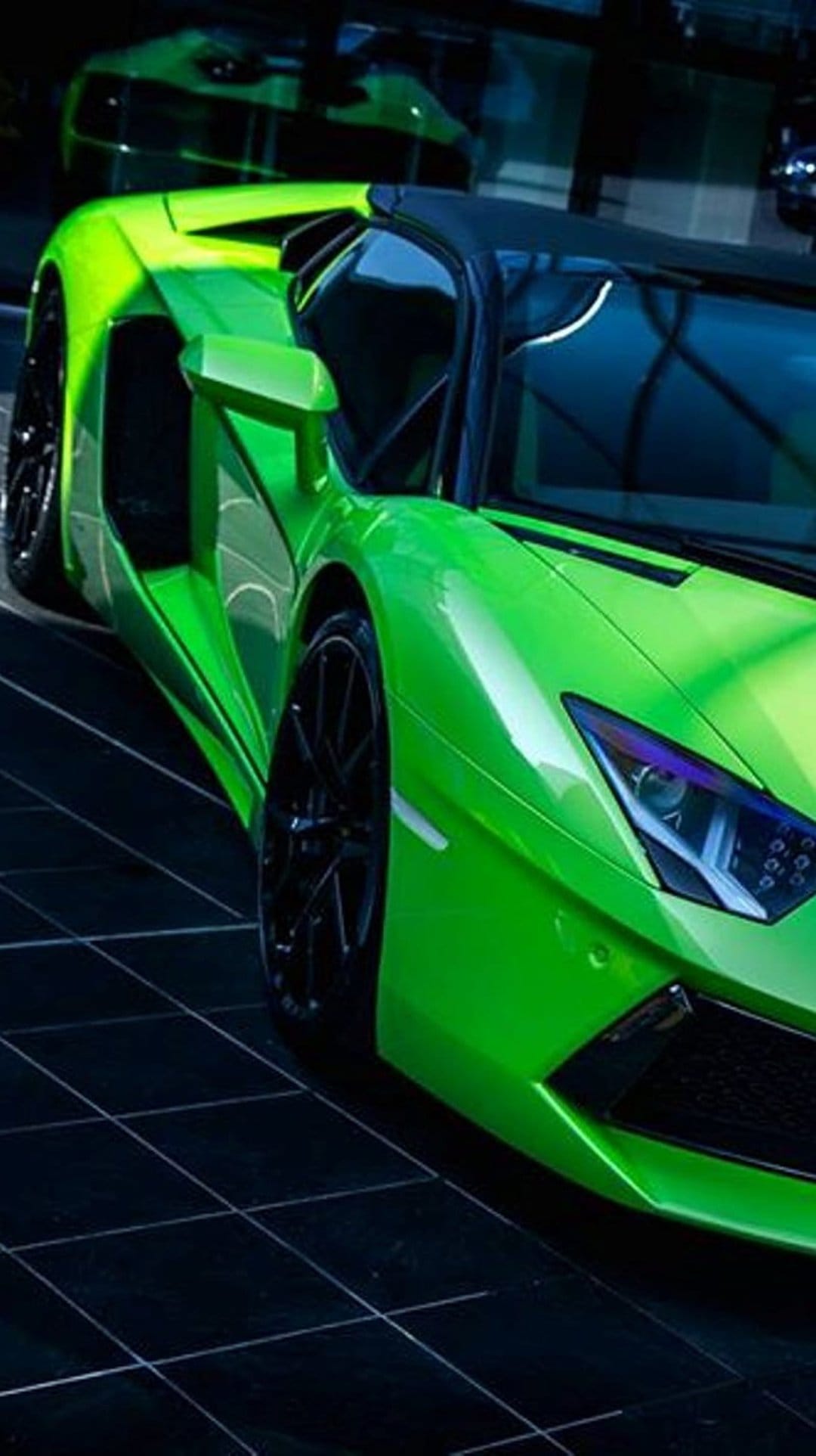 Neon green Lamborghini Aventador Roadster with a black leather interior sits on a dark reflective tile floor.