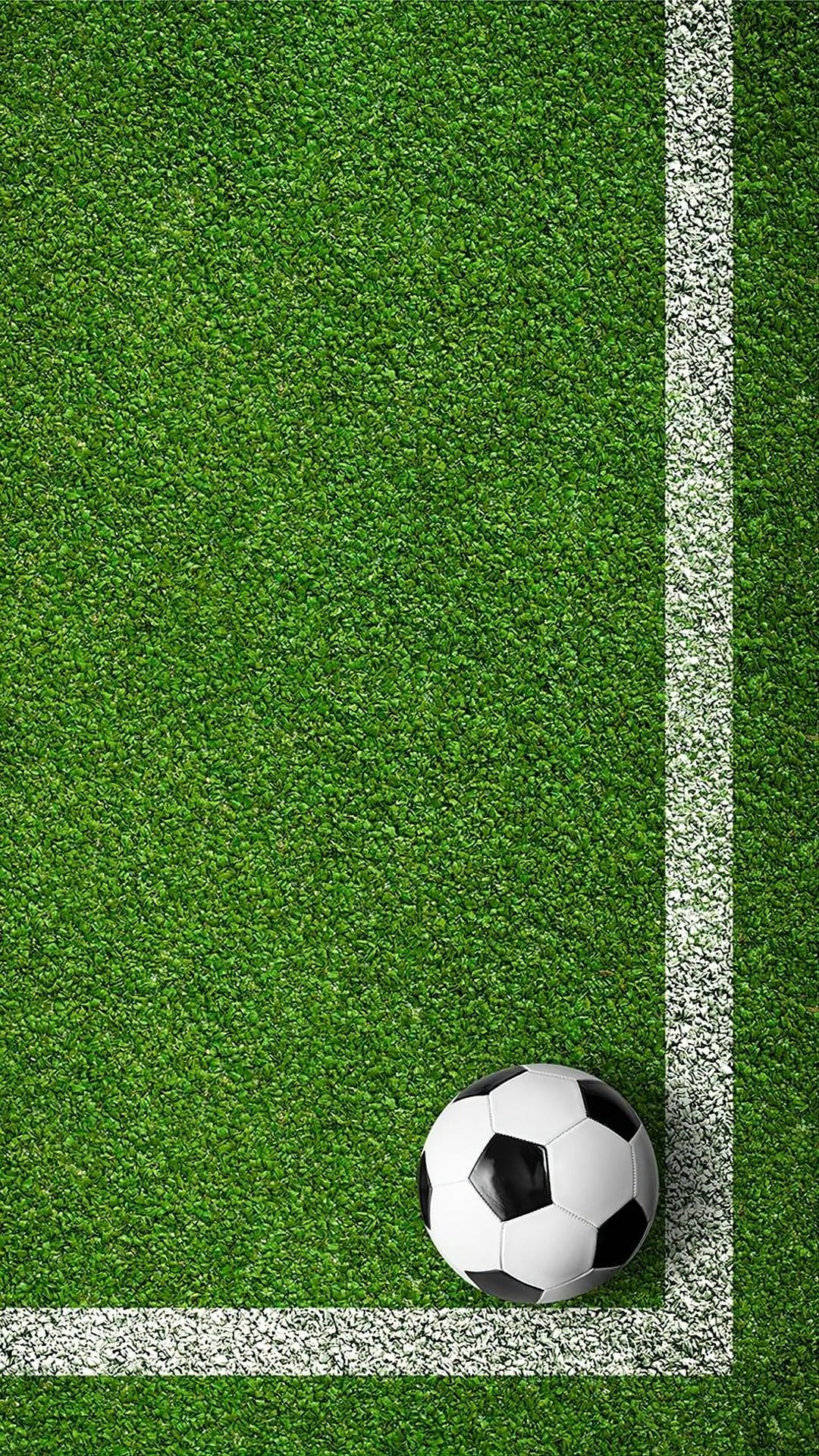 Black and white soccer ball rests on a bright green artificial turf field next to a solid white boundary line.