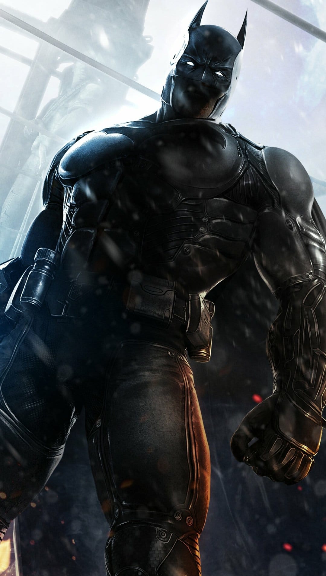 Batman in black tactical armor with glowing white eyes stands in a low-angle shot with snowy particles.