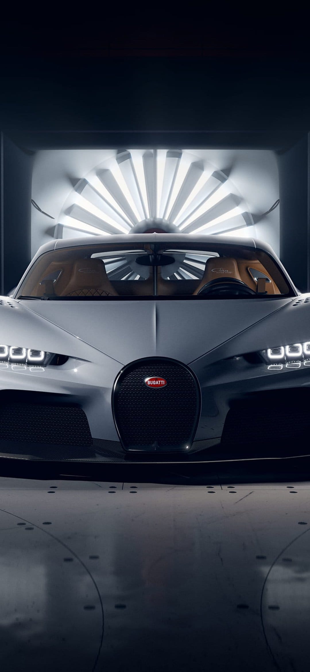 Silver Bugatti Chiron hypercar centered in a dark wind tunnel illuminated by concentric circles of white LED lights.