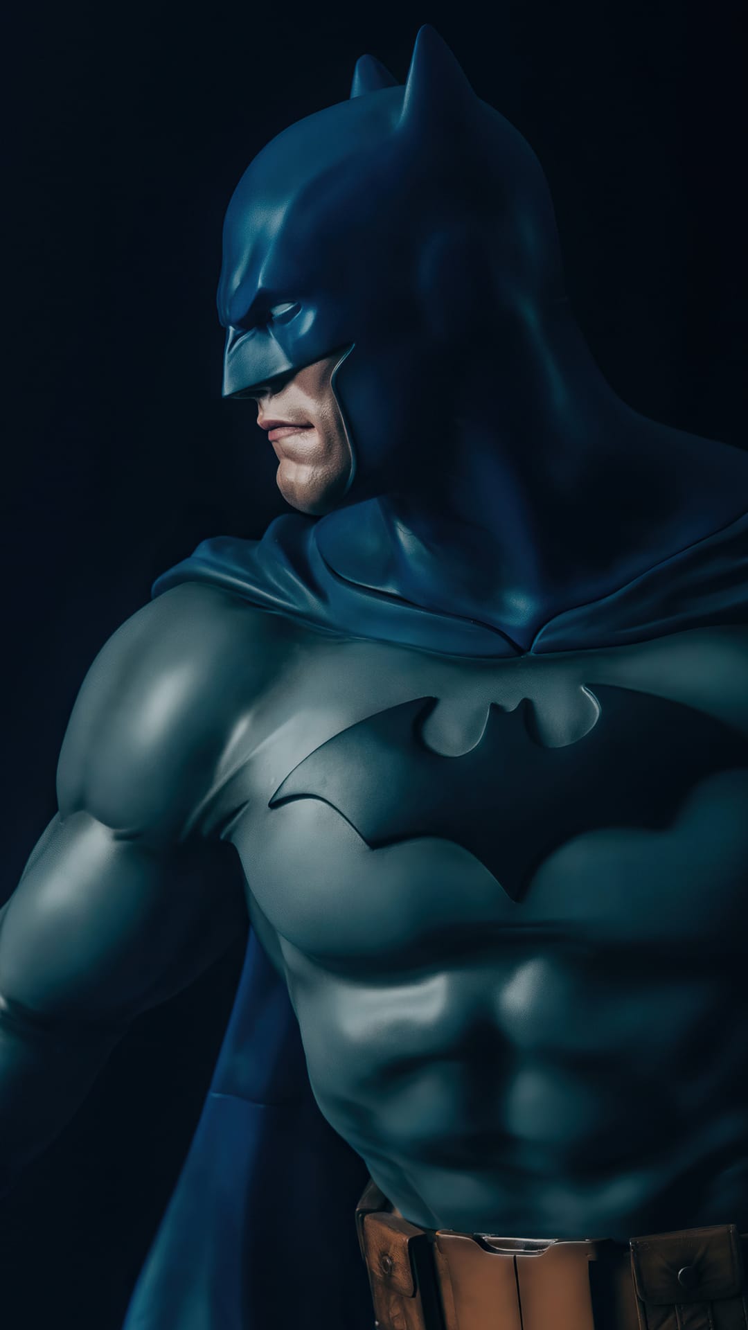 Batman statue with a dark blue cowl and grey armored suit featuring the bat symbol against a black background.