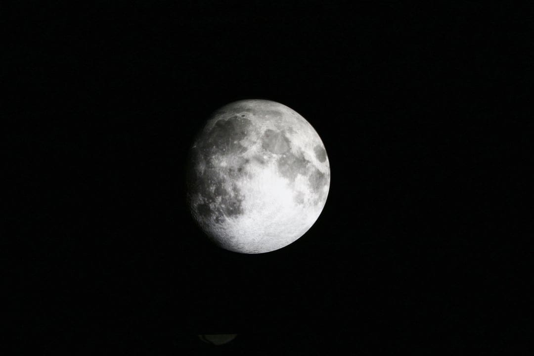 Full moon with visible craters and lunar maria centered against a solid black background in high detail.