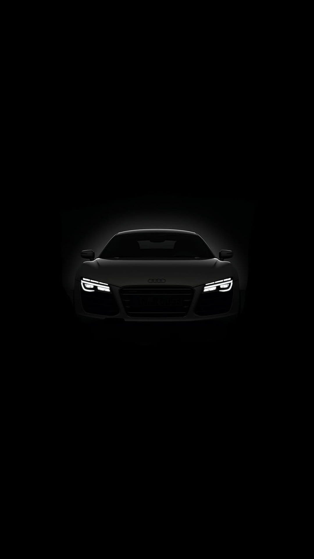 Audi R8 front view with illuminated LED headlights against a solid black background in vertical orientation.