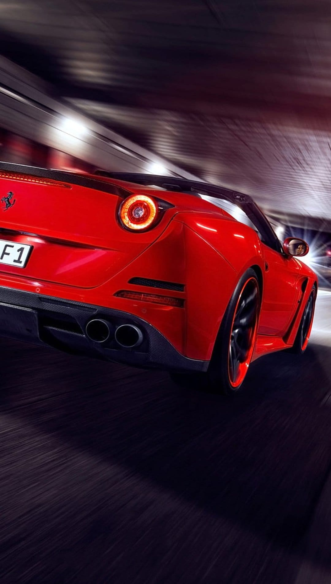 Red Ferrari convertible speeding through a dark tunnel with glowing red taillights and blurred concrete walls.