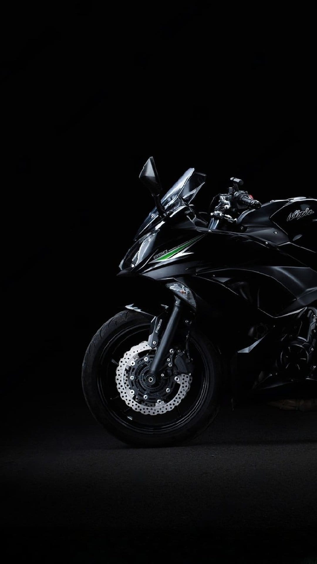 Kawasaki Ninja front wheel and disc brakes with green accents against a solid black studio background.