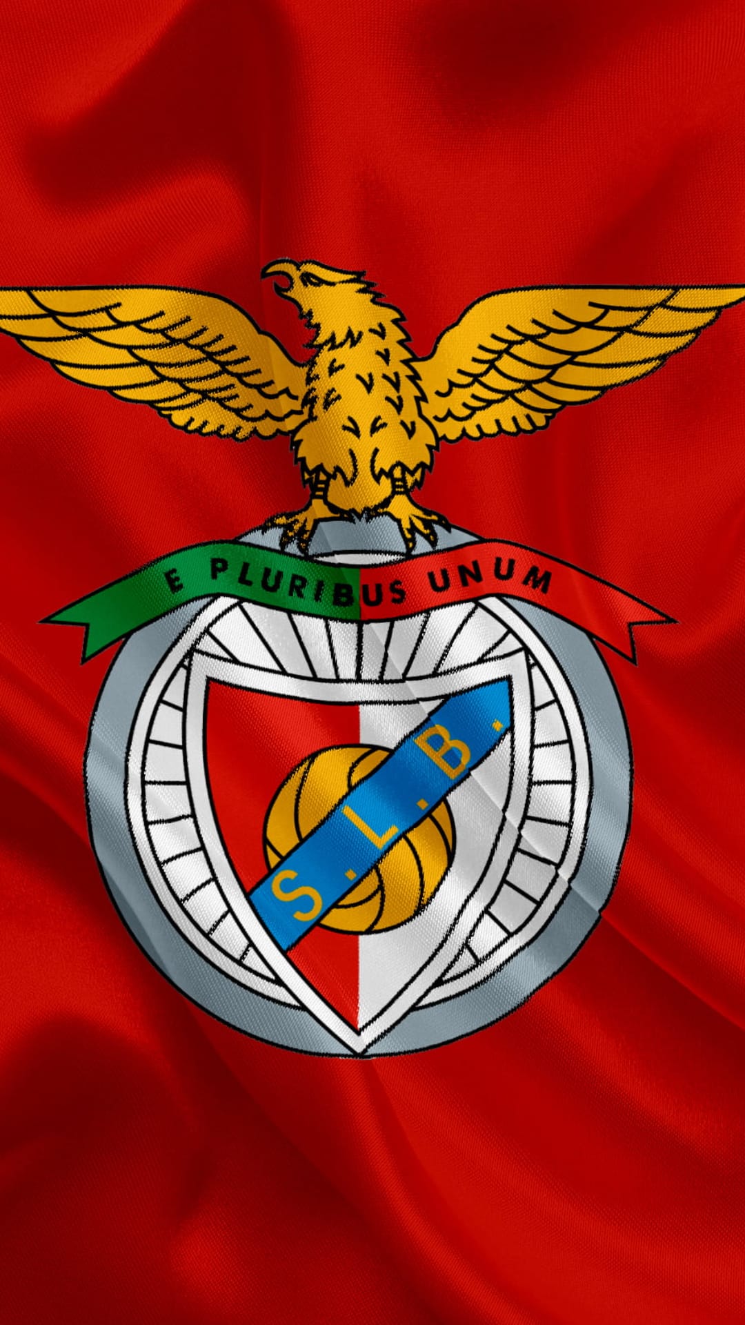 Golden eagle crest of SL Benfica centered on a waving red fabric background with deep shadows and highlights.