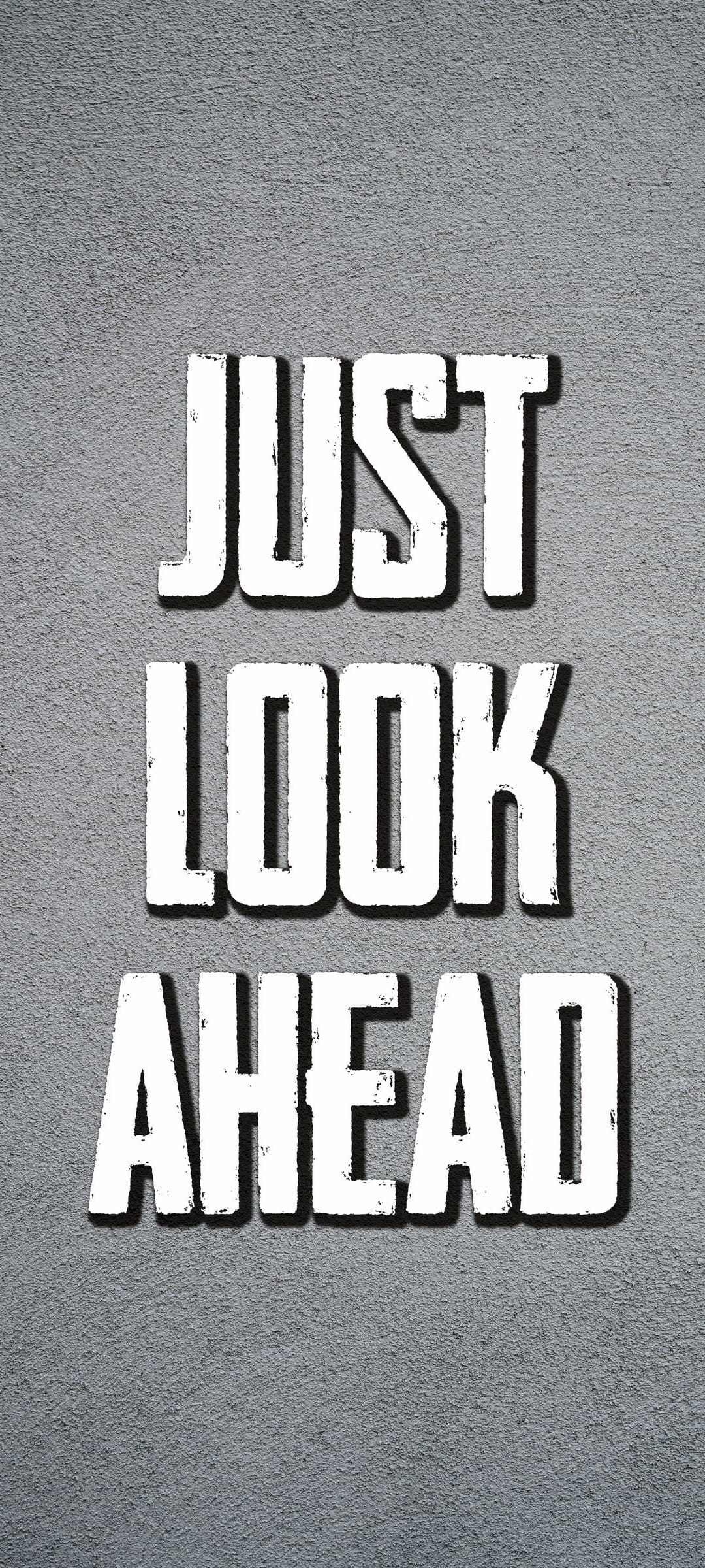 White 3D lettering spelling Just Look Ahead sits on a gritty gray textured surface with soft shadows.
