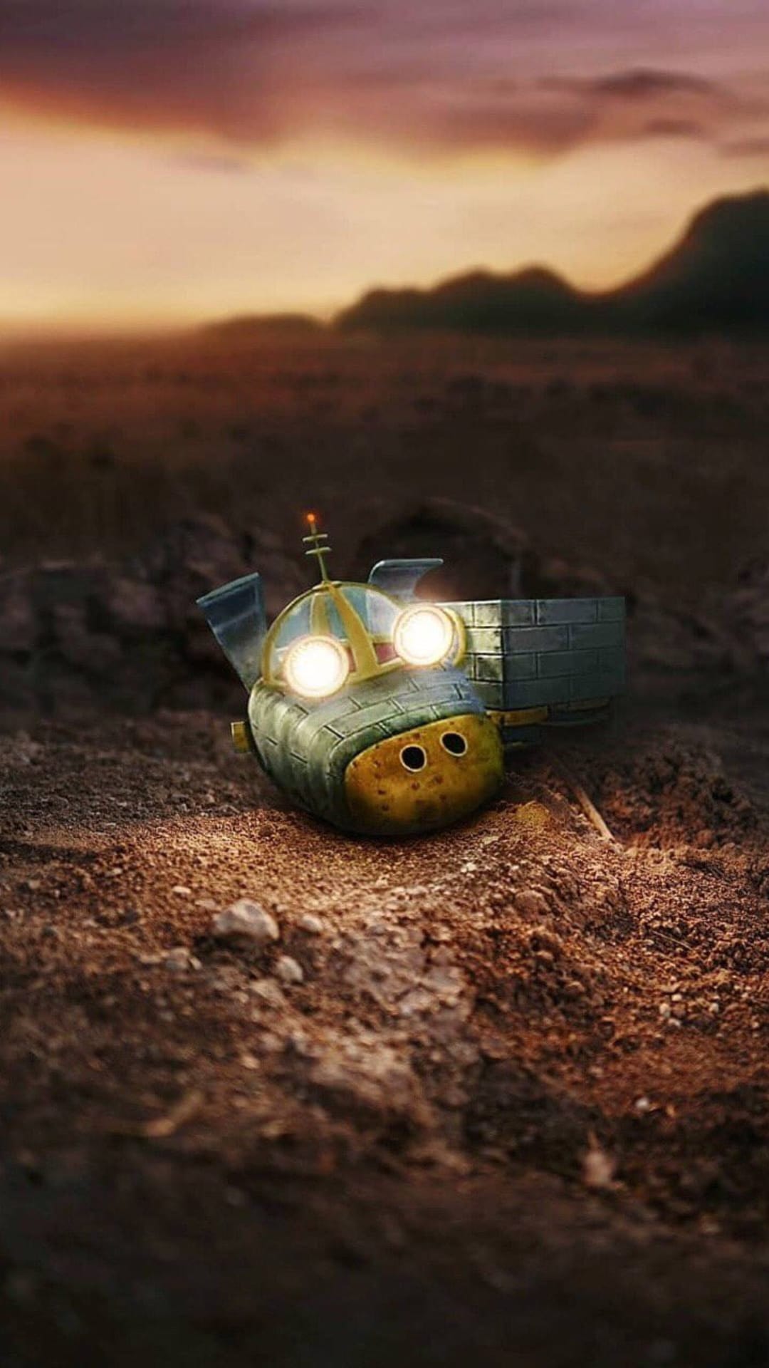 Tiny robot with glowing blue eyes rests on parched earth under a vibrant orange and purple sunset sky.