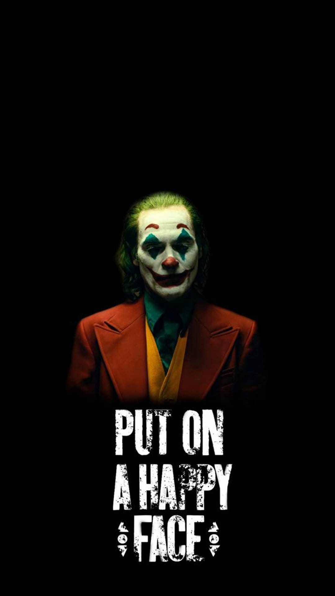 The Joker with green hair and a red smile glares from a dark background with text reading Put On A Happy Face.