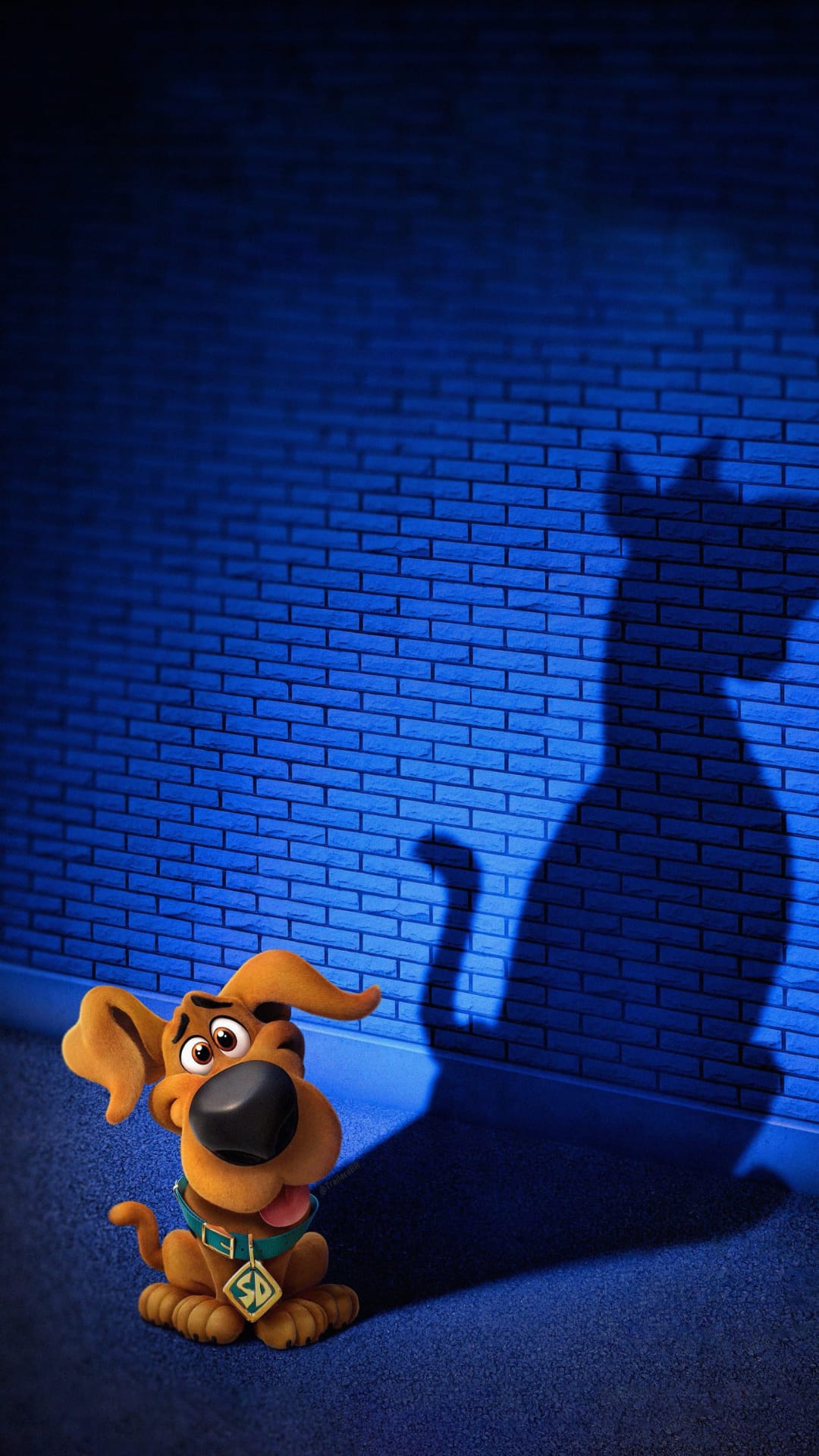Scooby-Doo sits on a blue carpet looking up at a large cat-shaped shadow cast on a textured blue brick wall.