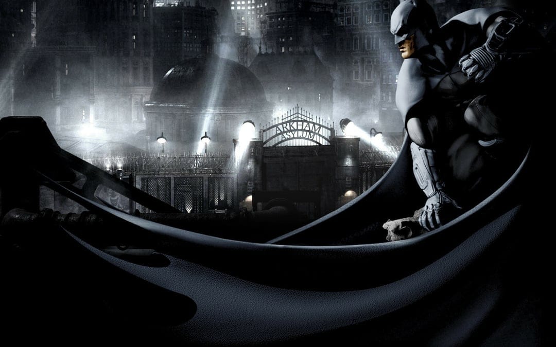 Batman crouches on a ledge overlooking the Arkham Asylum gate in a dark, foggy monochromatic night scene.