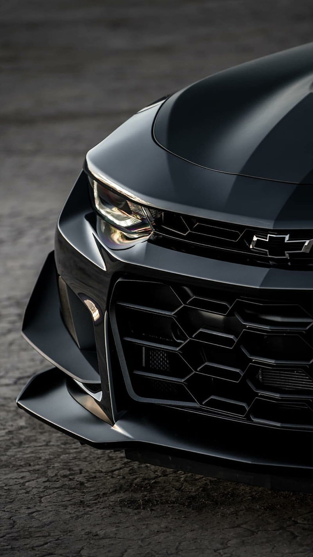 Black Chevrolet Camaro front end featuring LED headlights, a honeycomb grille, and a low-profile front splitter.