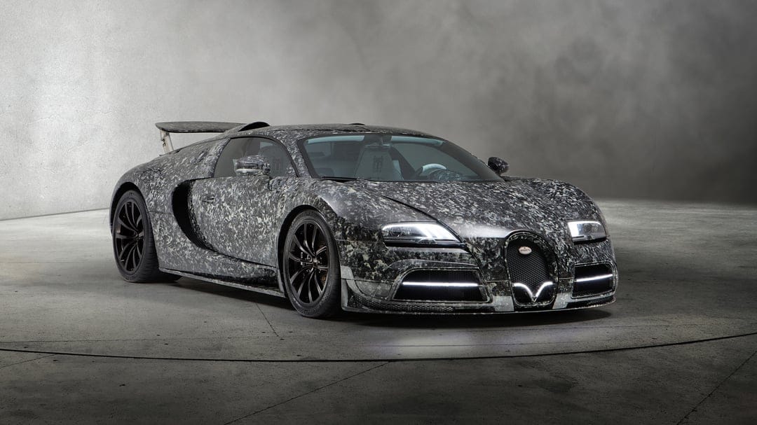 Front angle view of a Bugatti Veyron with a forged carbon fiber body in a minimalist gray studio setting.