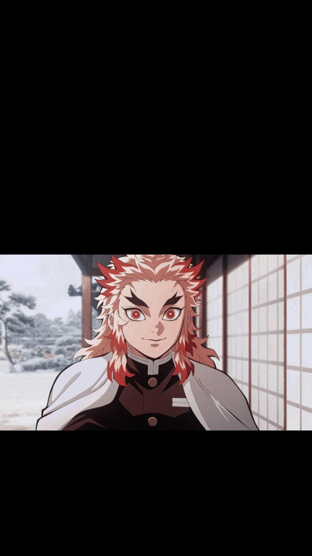 Kyojuro Rengoku smiles broadly with bright red eyes and flame-patterned hair before a traditional Japanese temple.