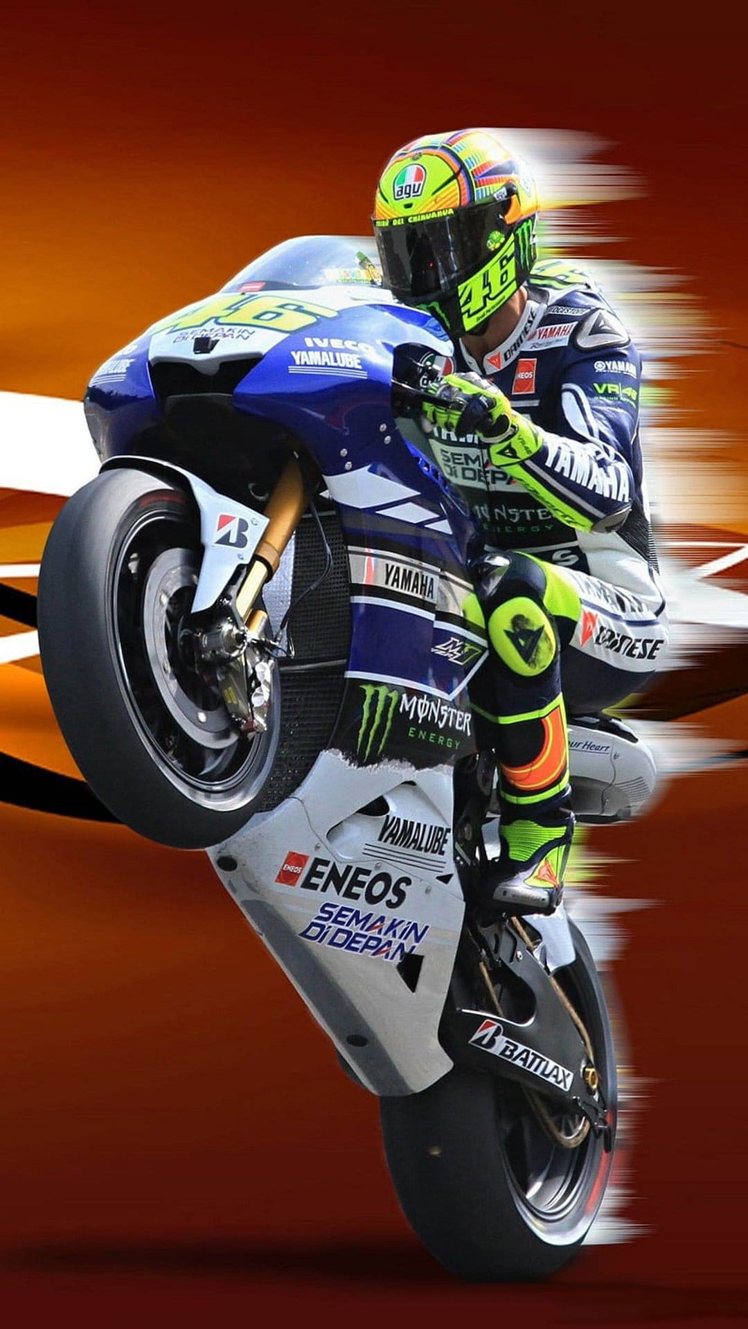 Valentino Rossi performs a wheelie on a Yamaha motorcycle wearing yellow racing gear and a number 46 helmet.
