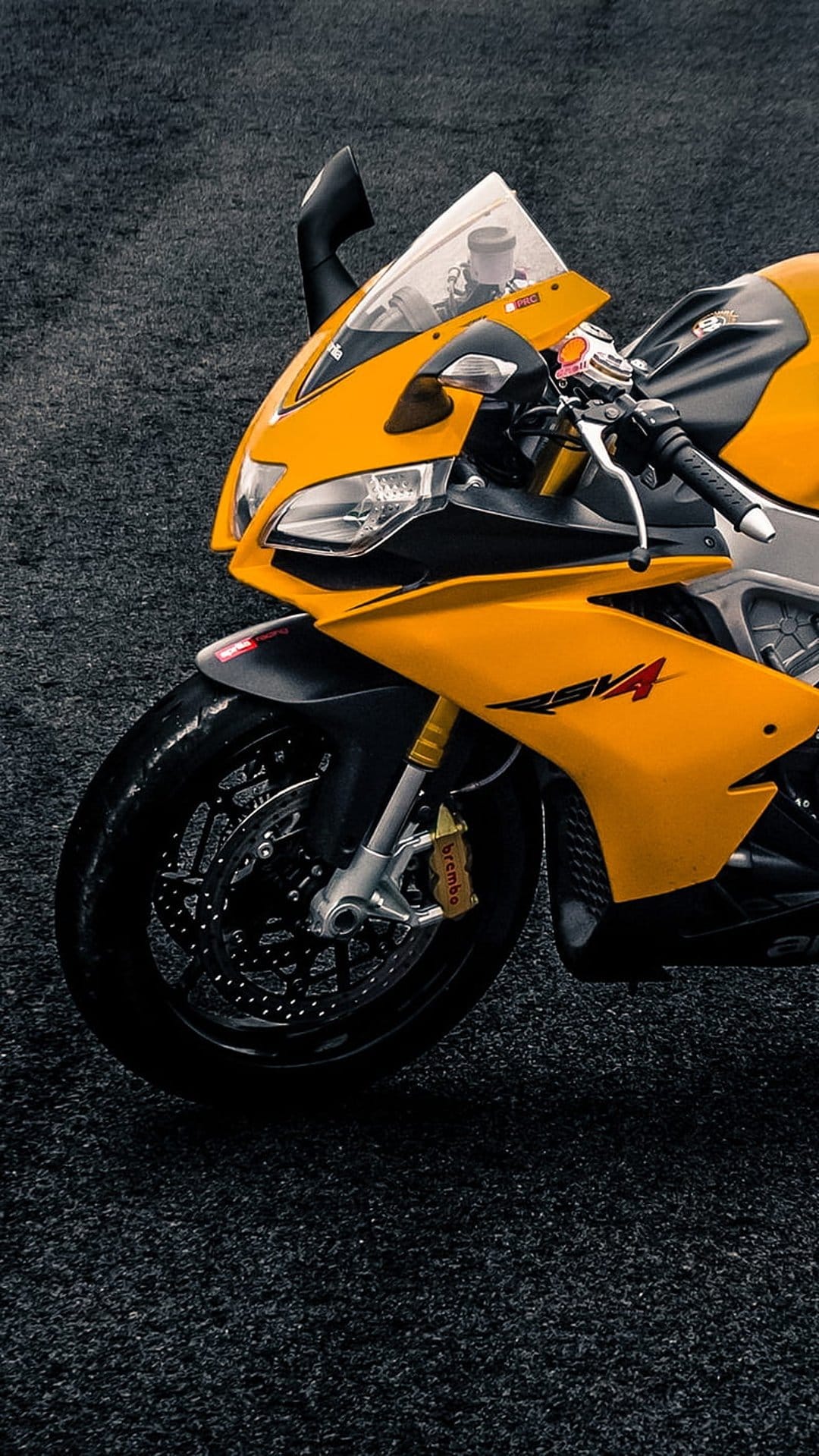 Yellow sportbike fairing and front wheel with Brembo brakes and gold suspension forks in a close-up detail shot.