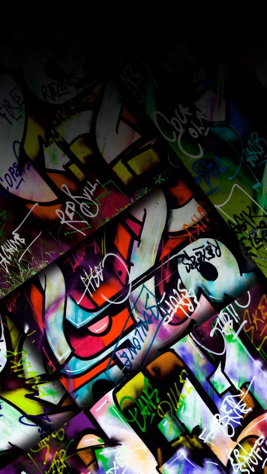 Overlapping graffiti letters and spray paint splatters in orange, purple, and blue cover a textured urban wall.