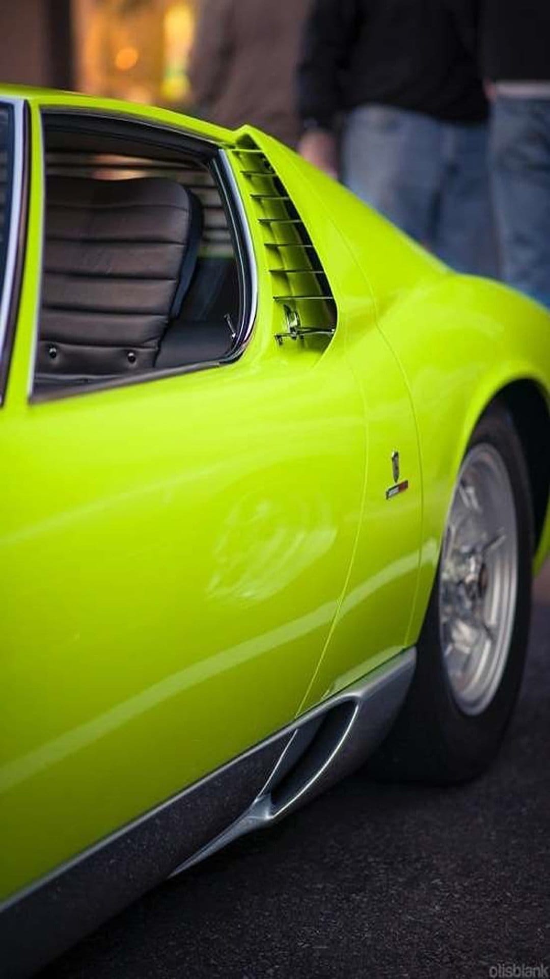 Lime green Lamborghini Miura SV side view showing black window louvers, chrome intakes, and a classic silhouette.