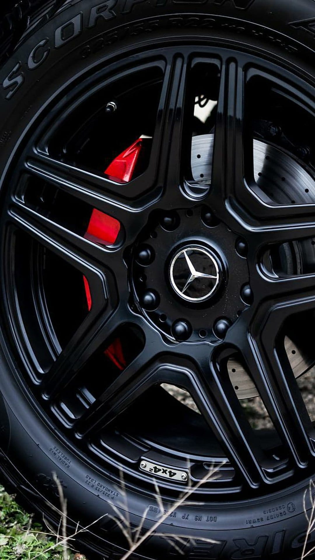 Mercedes AMG black multi-spoke wheel with red brake calipers, a silver center logo, and detailed tire textures.