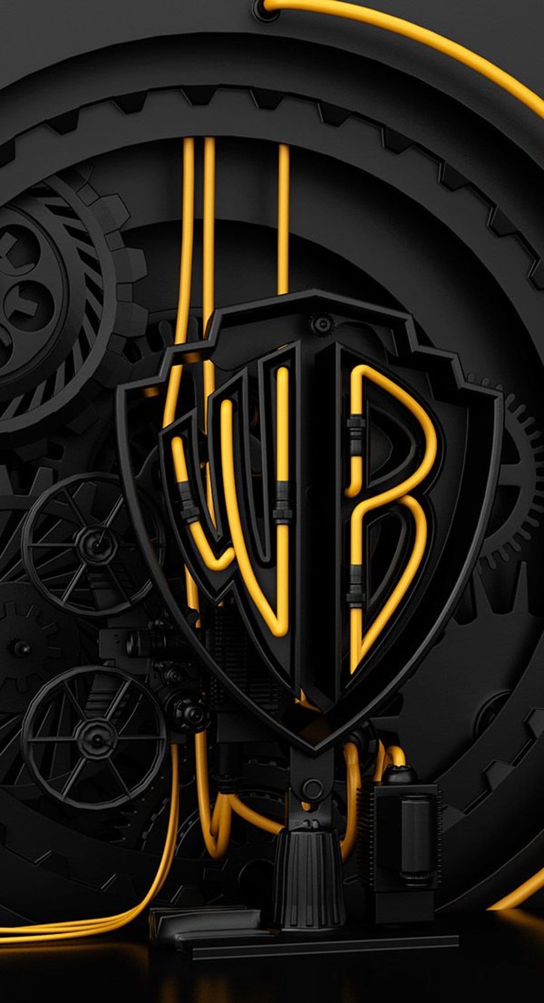 Warner Bros shield logo illuminated by yellow neon tubes surrounded by dark mechanical gears and cables.